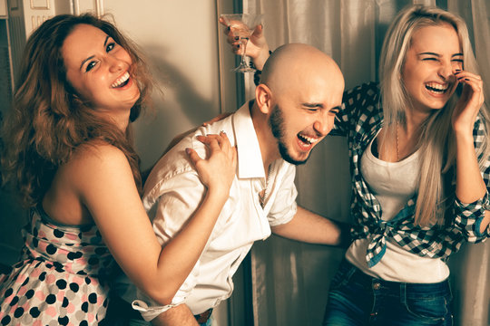 man with two charming girls laughing at a party