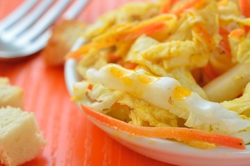 salad with Chinese cabbage, carrots and egg pancakes. close up.