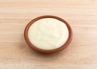 Bowl of blue cheese salad dressing on wood table