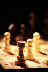 Chess pieces and game board on black background