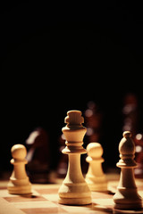 Chess pieces and game board on black background