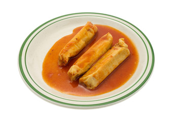 Serving of tamales in chili sauce on plate