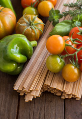 Raw fettucce pasta, vegetables and herbs
