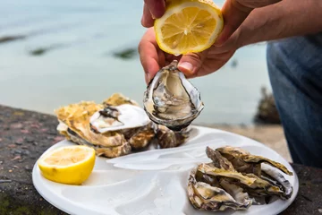 Gordijnen Male hand holding oysters © dvoevnore