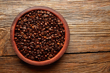 Obraz na płótnie Canvas Coffee beans in a clay dish texture on wood
