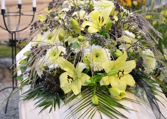 Blumengebinde auf Sarg - Lilien und Chrysanthemen mit Gräsern