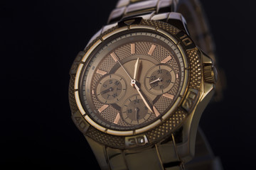 Gold watch on a plastic background