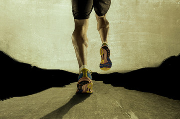 strong athletic legs with ripped calf muscle of young sport man running on grunge asphalt road