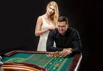 Men with women playing roulette at the casino. 