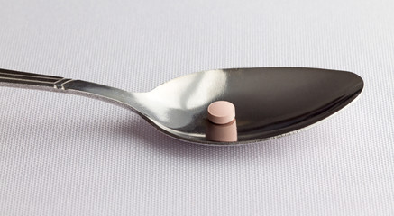 Famotidine tablet on a spoon