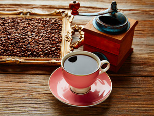 Coffee cup with vintage grinder on wood table