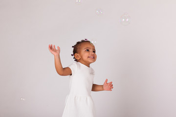 Portrait of little African American little girl playing with soa