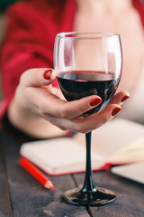 Woman touching glass of red wine