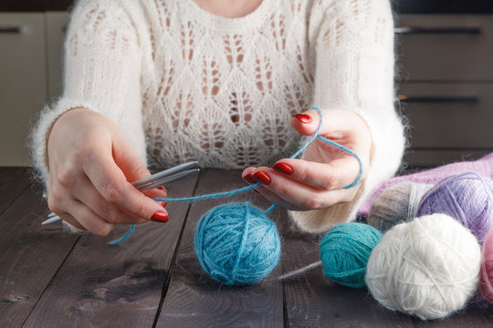 woman is knitting on a kitchen table