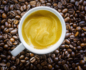 Cup of Coffee on and with Coffee Beans