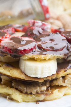 delicious pancakes with nuts, banana, strawberry and chocolate