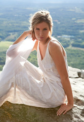 Fototapeta na wymiar Beautiful Woman in White Dress in Mountains