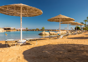 Straw umbrellas and sunbeds on the wonderful tropical beach. 