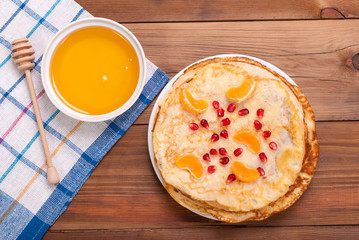 Pancakes and honey on a wooden table. Top view .