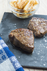 cooked beef chateaubriand steak with chunk chipped potatoes on p