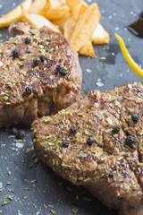 Grilled T-bone steak seasoned with spices and fresh herbs served