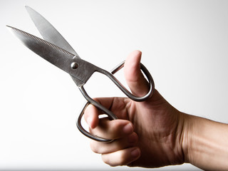 Hand holding a pair of sharp scissors