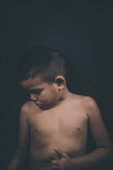 Naklejka premium scared and alone, young Asian child who is at high risk of being bullied, trafficked and abused