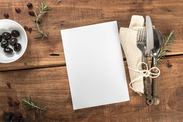 Rustic Old Wooden Table With Cutlery and White Paper Menu
