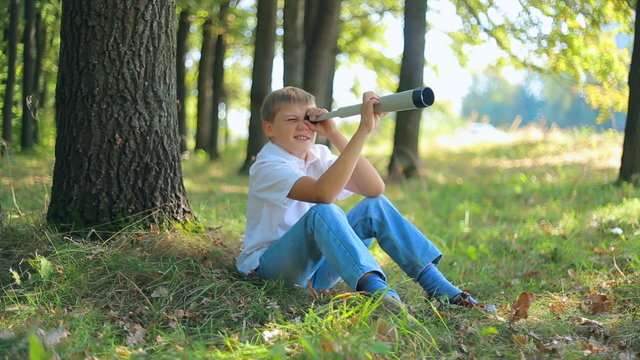 Caucasian child teen boy looking through a telescope. Childhood dreams and memories.
