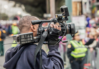 News Photographer / A news cameraman at a large event in the city.