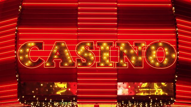 The word casino is lit up in neon lights at night on Freemont Street in Las Vegas