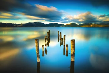 Gartenposter Seebrücke Hölzerner Pier oder Steg bleibt auf einem blauen Seesonnenuntergang und -himmel refle