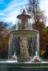 A flowing fountain in the Park of Madrid, Spain on a warm November day.  Warm November day in one of the main parks of the city.