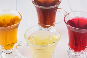 Glass tea cups with assorted tea.
