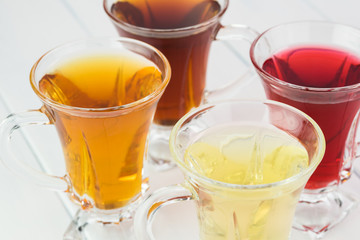Glass tea cups with assorted tea.