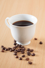 Coffee Cup on Wood Table with Coffee Beans