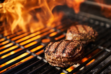 steaks on the grill with hot flames