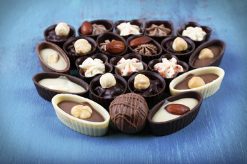 Chocolate sweets on old blue wooden background, top view