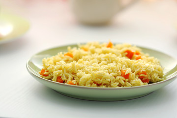 Stewed rice with a carrot on a plate