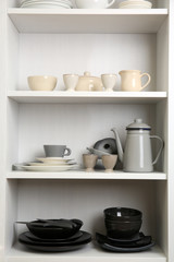 Obraz na płótnie Canvas Tableware on shelves in the kitchen cupboard