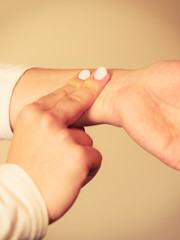 Woman checking pulse on wrist closeup