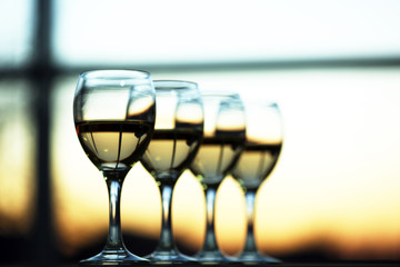 Row of wineglasses on light blurred background