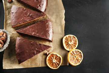 Pieces of frosting chocolate cake on black table