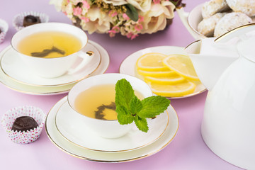 Tea cups with green tea and cookies.