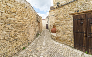 Fisheye view on vanishing medieval narrow pavement street passage with stonemasonry building. Pano Lefkara, Cyprus.
