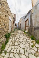 Fisheye view on vanishing medieval narrow pavement street passage with stonemasonry building. Pano Lefkara, Cyprus.
