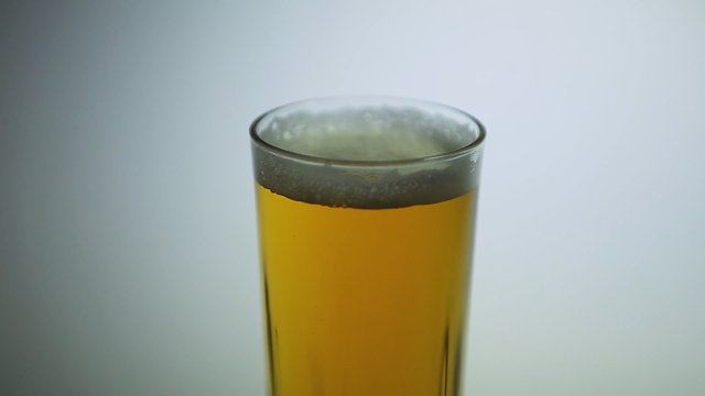 Fresh foamy beer  in a glass (isolated on white background). Big belly, overweight, obesity