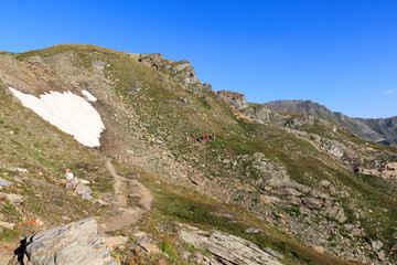 Mountain panorama and people hiking on footpath in Hohe Tauern Alps, Austria