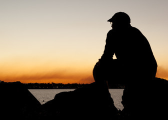 Man in silhouette sitting quietly contemplating