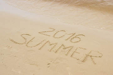 Summer 2016 drawn on sand at the beach by the sea